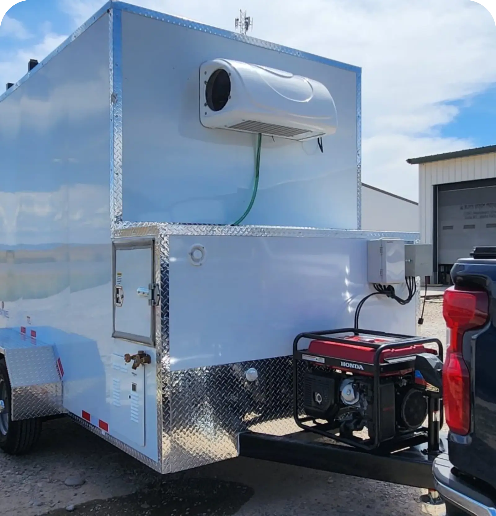 A metallic trailer with a mounted generator and vent pipe.